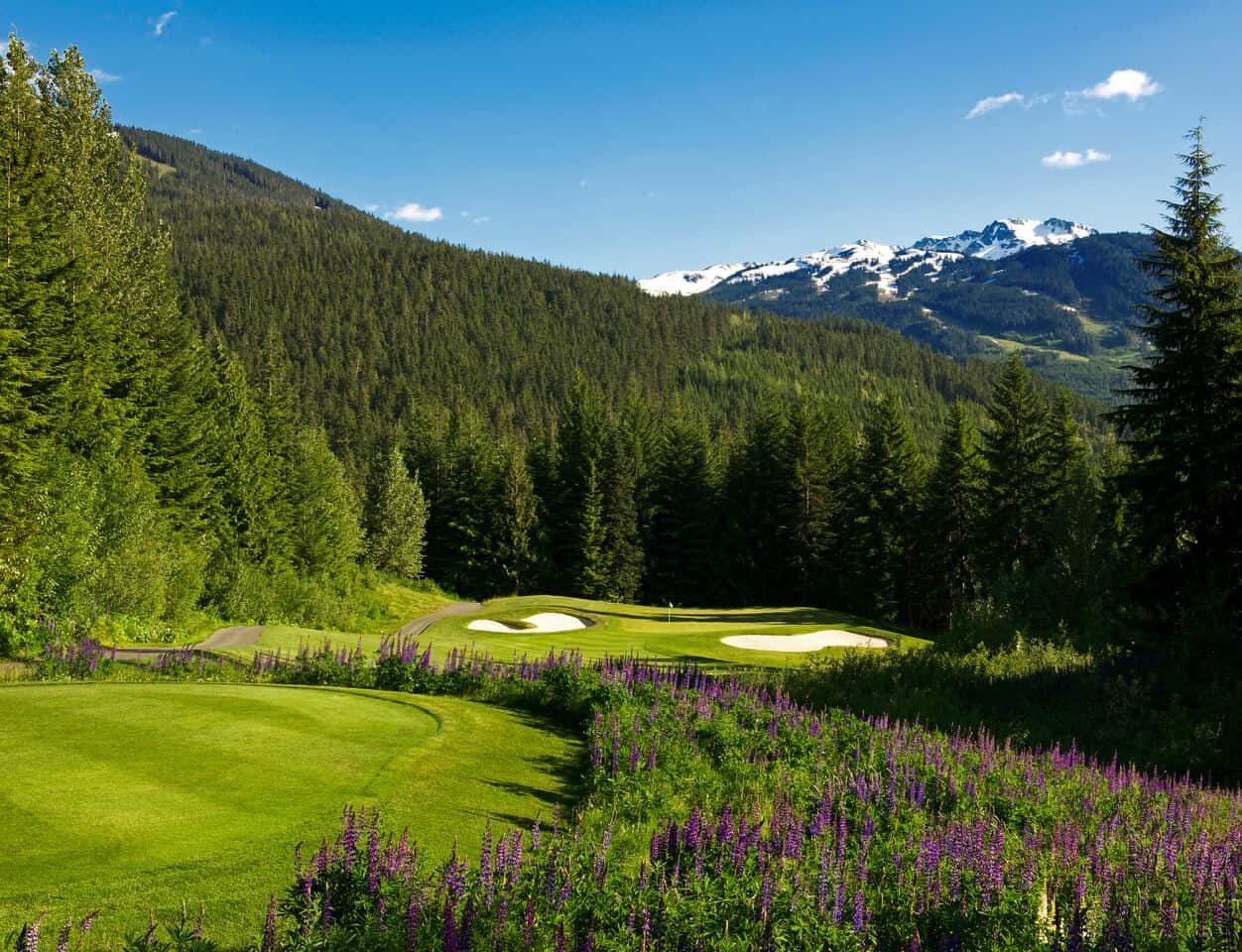 Mountains crest over the top of the fairmont whistler golf course